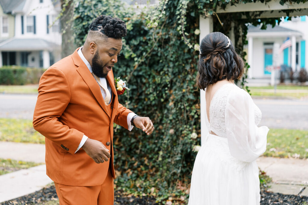 Groom gets excited to see bride in wedding dress for the first time and the lace details. First look added to wedding day timeline