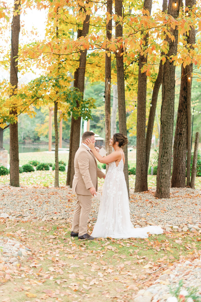 Bride and groom read vows in front of grove of fall leaves and trees photo taken by Baltimore wedding photographer