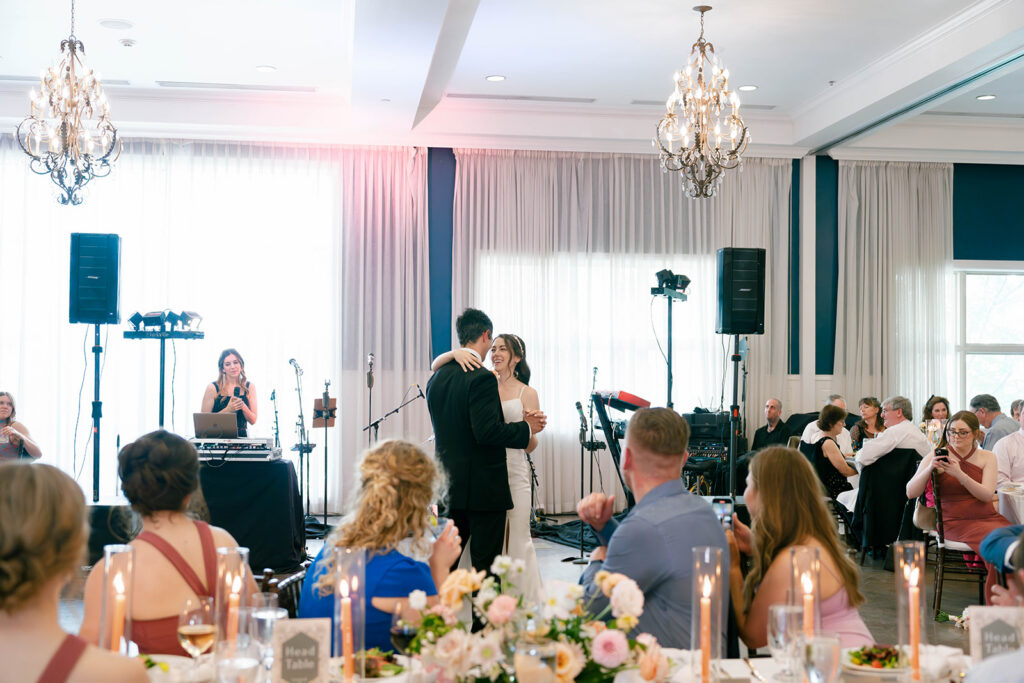 Bride and groom do their first dance inside of  Hotel Ella with friends and family watching