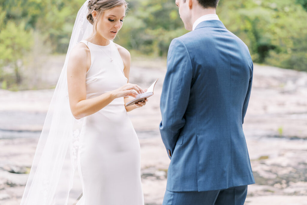 bride shares her private vows with her new husband before the ceremony alone at a riverside
