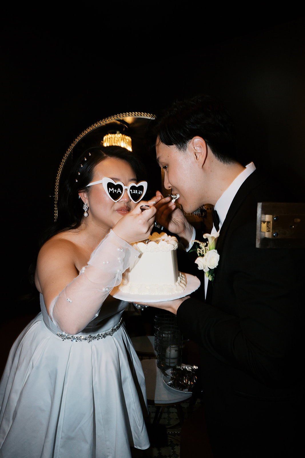 Bride and groom eat cake at their Baltimore wedding reception