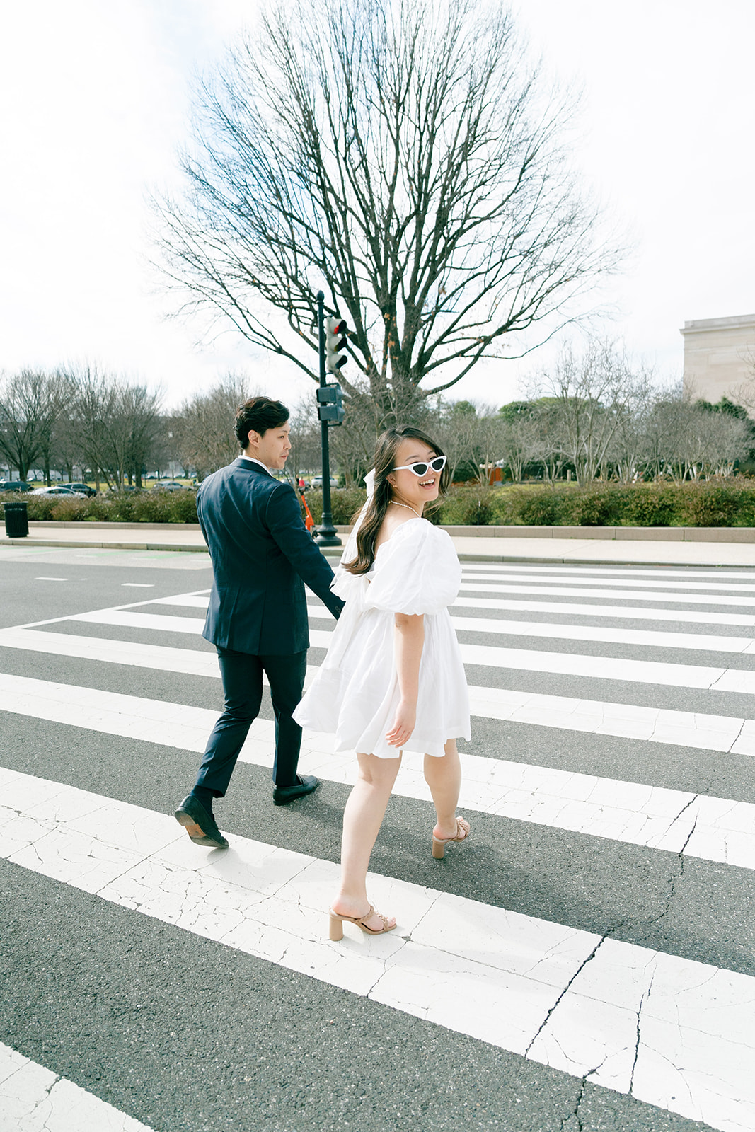 Couple crossing the street outside of their National Gallery of Art engagement photos