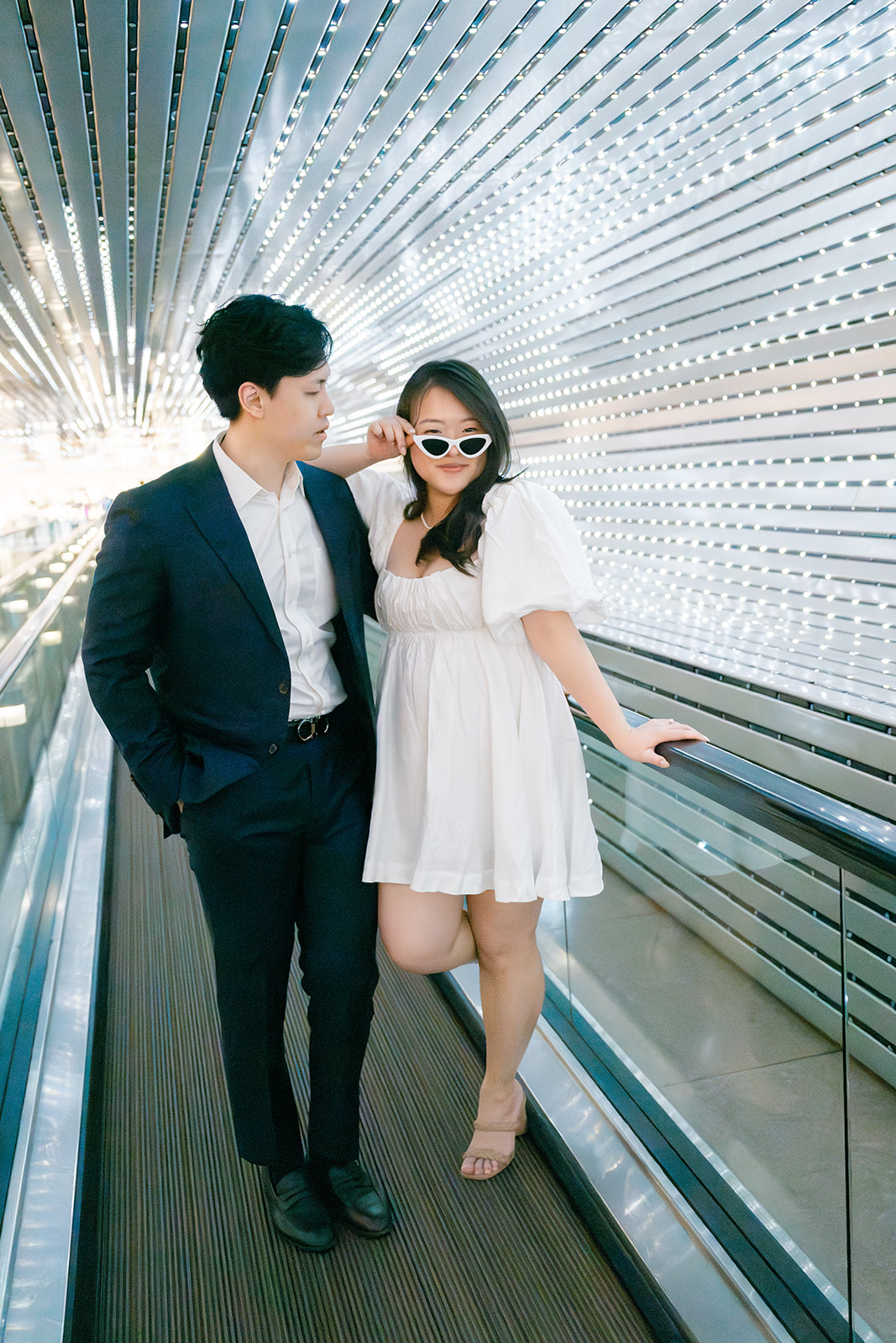 Couple on a moving walkway during their National Gallery of Art engagement photos